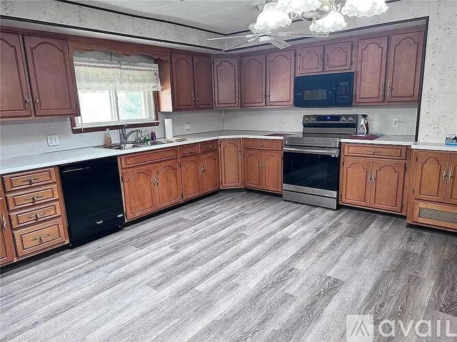 A kitchen with wooden cabinets and a grey floor.