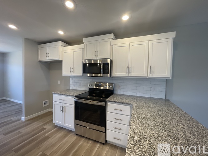 A kitchen with white cabinets and a black stove top oven.