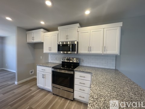 A kitchen with white cabinets and a black stove top oven.