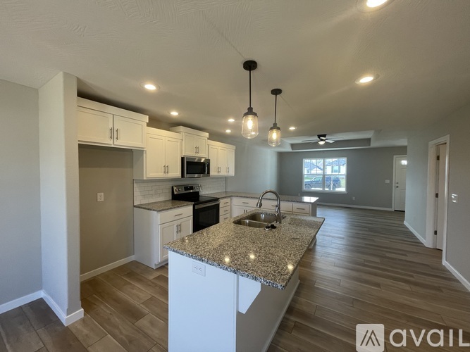 A kitchen with granite countertops and white cabinets.