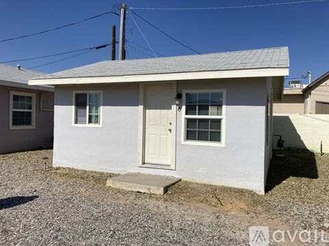 A small white house with a grey roof and a door is shown.