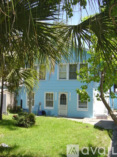 A blue house with a white door and windows.