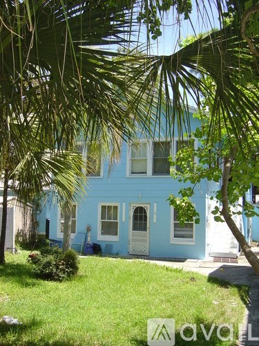 A blue house with a white door and windows.