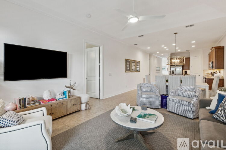 A living room with a grey rug and a white sofa.