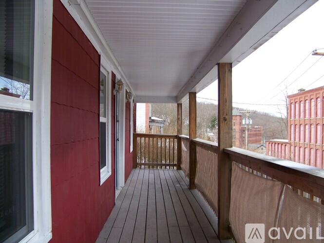 A red building with a wooden deck and white trim.