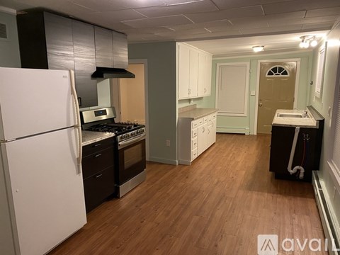 A kitchen with a white refrigerator and wooden floors.