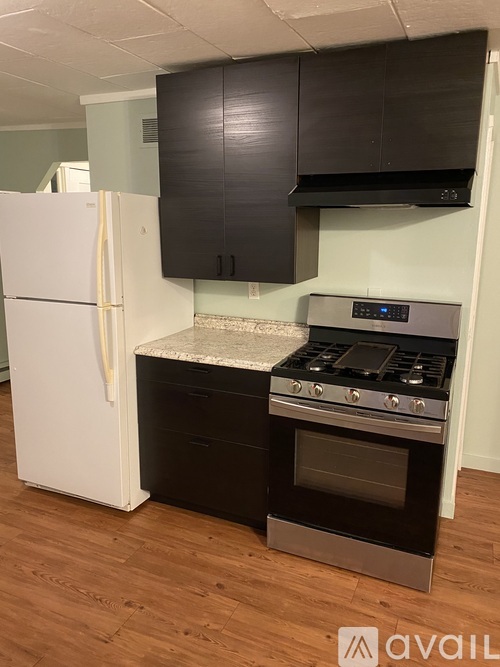 A kitchen with a white fridge and a black stove top oven.