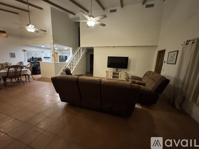 A living room with a brown couch and a television.