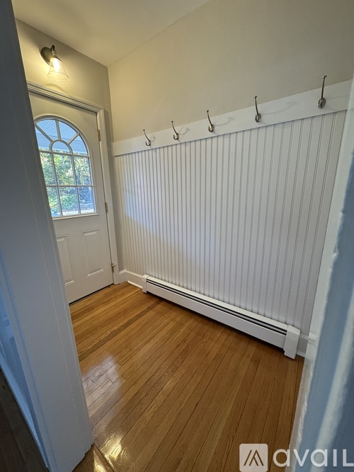 A room with a white radiator and wooden flooring.