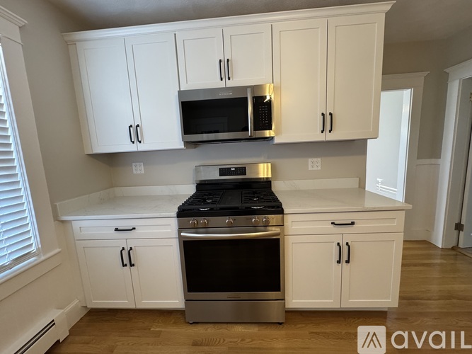 A kitchen with white cabinets and a stainless steel oven.