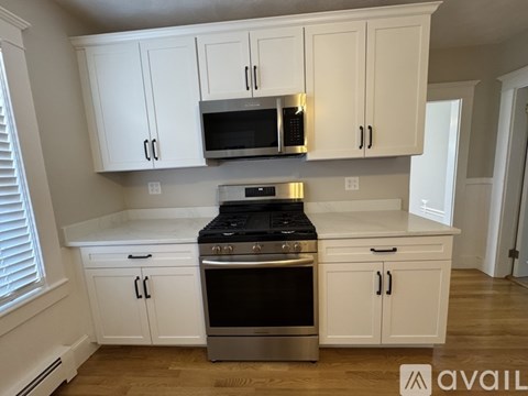 A kitchen with white cabinets and a stainless steel oven.