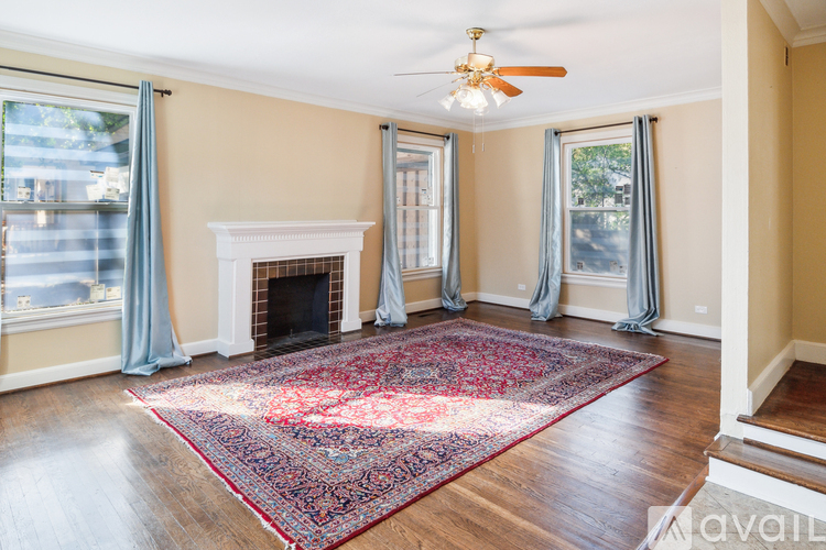 A living room with a fireplace and a rug on the floor.