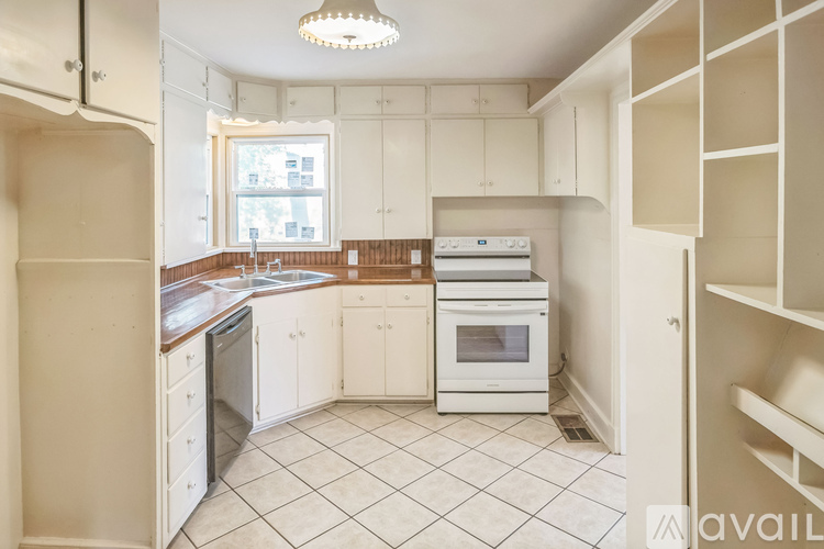 A kitchen with white cabinets and appliances.