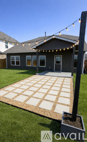 A house with a brown roof and a brick patio in front.