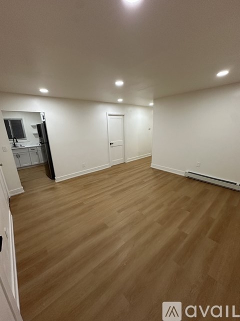 A room with wooden flooring and white walls.