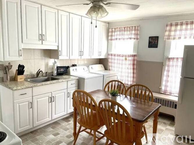A kitchen with a table and chairs.