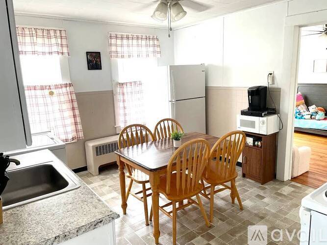 A kitchen with a table and chairs.