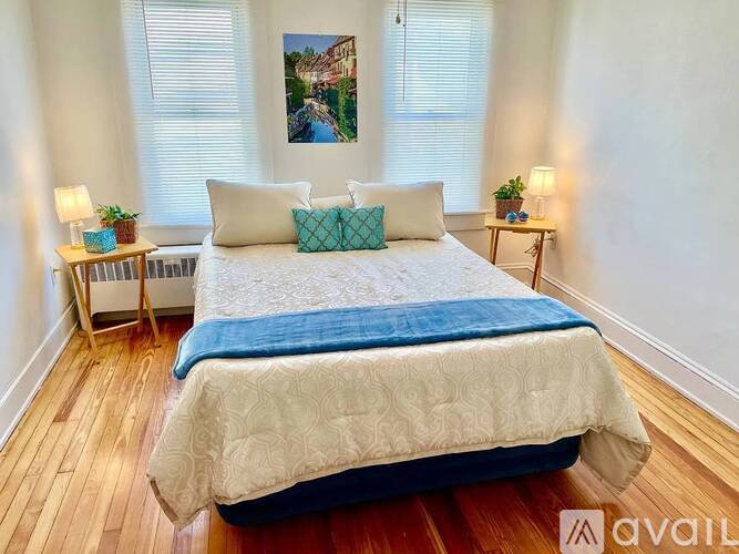 A bedroom with a large bed and a painting on the wall.