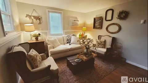 A living room with a white couch, a wooden coffee table, and a rug.