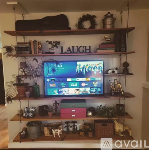 A television on a shelf with the word "LAUGH" written on it.
