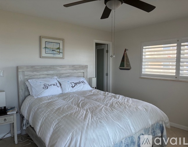 A bedroom with a large bed and a ceiling fan.