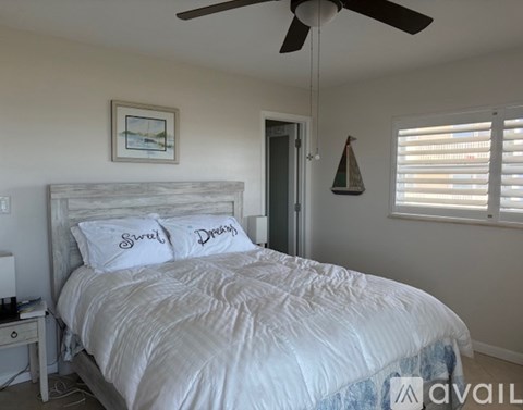 A bedroom with a large bed and a ceiling fan.