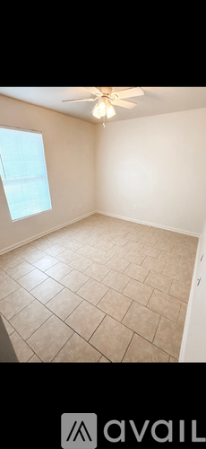 A room with a ceiling fan and a window.