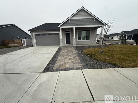 A house with a grey roof and a grey garage door is shown.