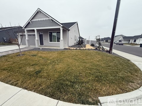 A house with a grey roof and a small front yard.