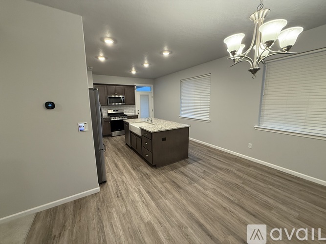 A spacious room with a kitchenette and a chandelier.