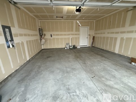 A spacious empty room with a concrete floor and walls covered in insulation.