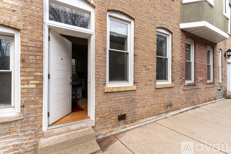 A brick building with a white door and windows.