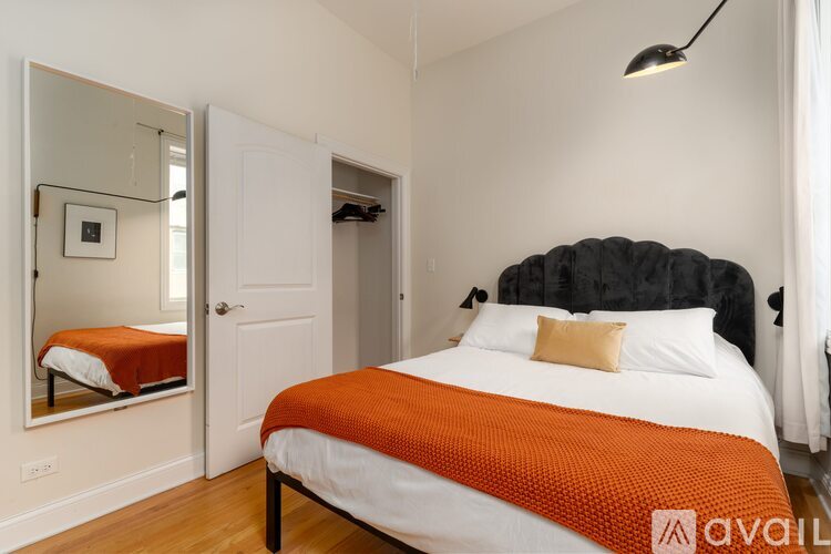 A bedroom with a large bed and a mirror on the wall.