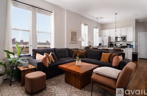 A living room with a grey couch and a patterned rug.
