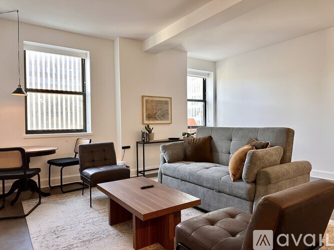 A living room with a grey couch and a brown chair.