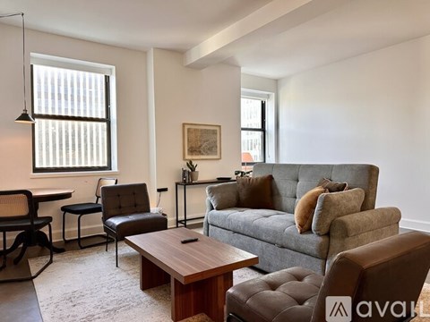 A living room with a grey couch and a brown chair.