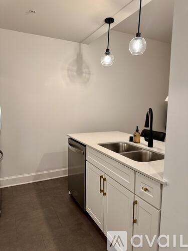 A kitchen with white cabinets and a sink under a mirror.
