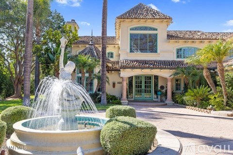 A large house with a fountain in front of it.