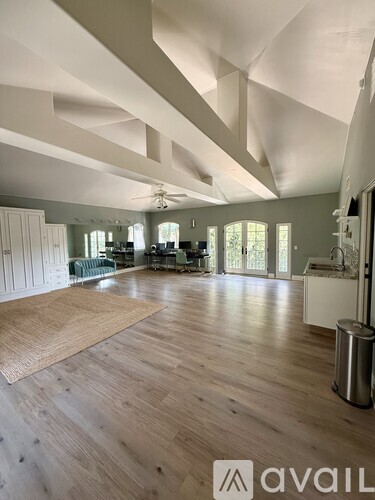 A spacious room with wooden floors and white walls.