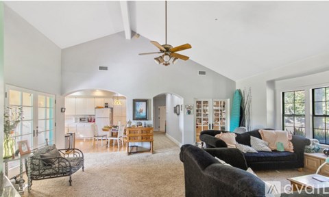 A spacious room with wooden floors and white walls.