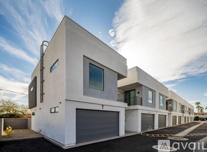 A modern white house with a garage door and a window.