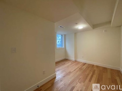 A room with wooden flooring and a window.
