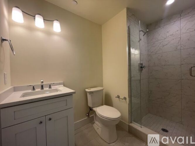 A bathroom with a toilet, sink, and shower.