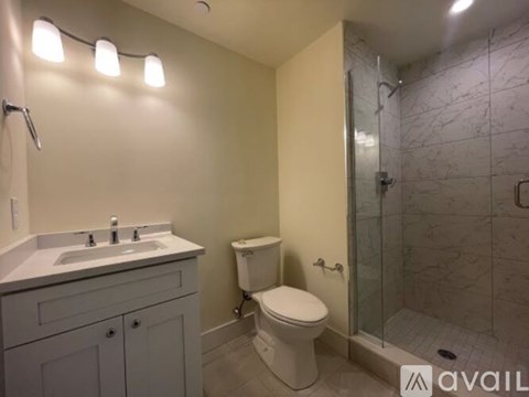 A bathroom with a toilet, sink, and shower.