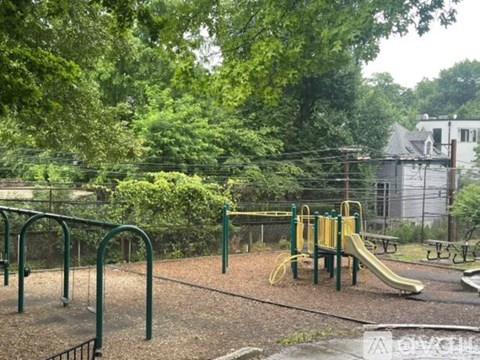 A playground with a yellow slide and green metal bars.