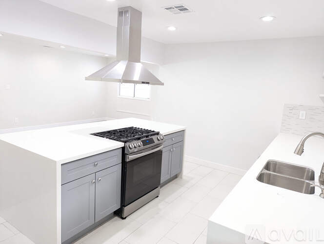 A modern kitchen with a stove and sink.
