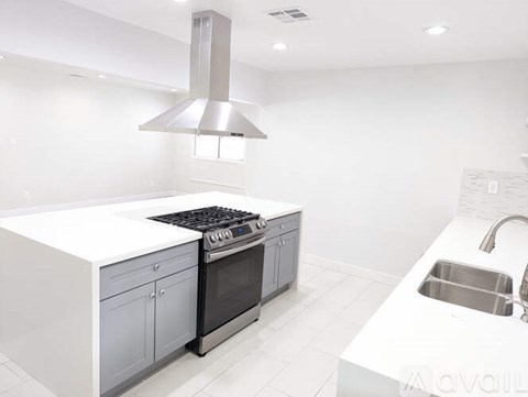 A modern kitchen with a stove and sink.