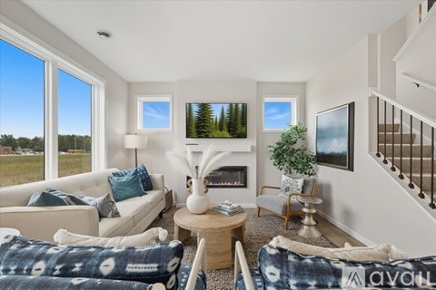 A living room with a couch, a chair, a coffee table, and a fireplace.