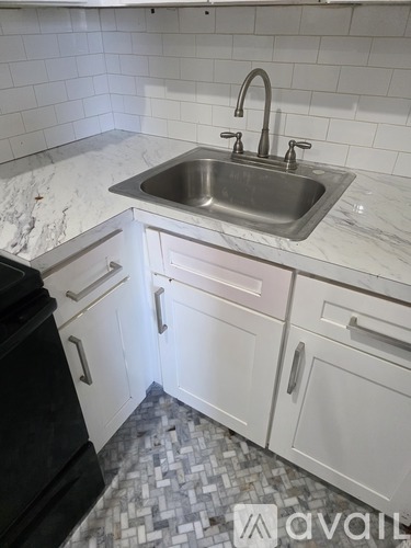 A kitchen with a sink and a black dishwasher.