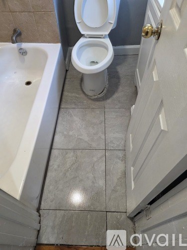 A white toilet is in a bathroom with a white sink.